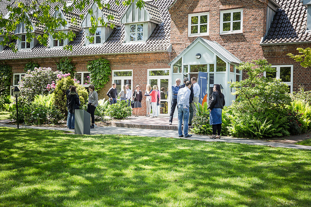 Menschen unterhalten sich vor der Nordsee Akademie.